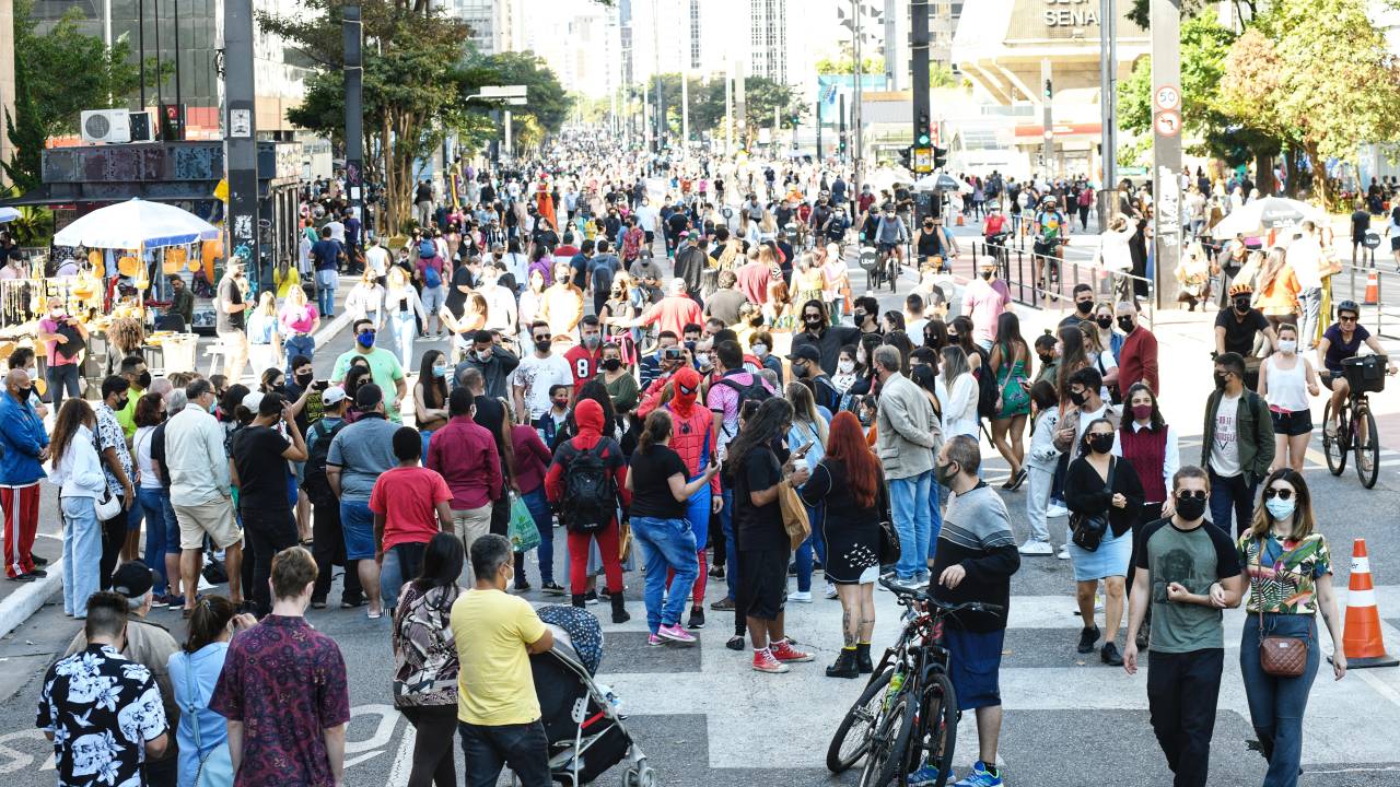 Imagem mostra grande quantidade de pessoas na Avenida Paulista neste domingo ensolarado de inverno. Muitas pessoas usam máscaras, mas muitas também não usam