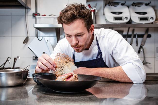 Miró Gastronomia Dalton Rangel finalizando preparo de prato em bancada da cozinha.