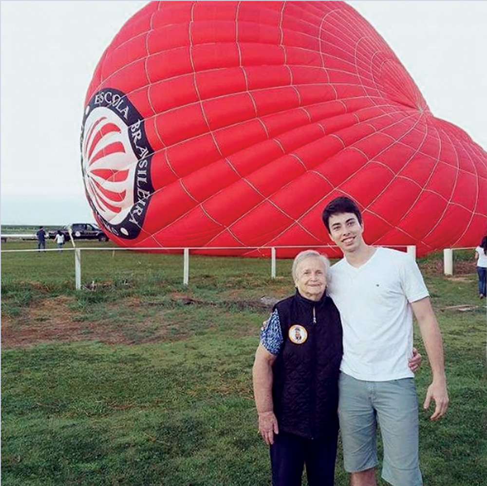 felipe e joanna nascimento posando para a foto em campo em Boituva, com balão vermelho ao fundo