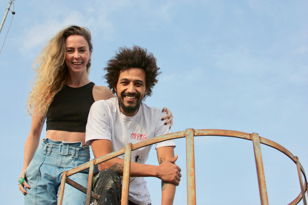 casal fernanda de pagu posando para a foto em cima de uma superfície com corrimão olhando para baixo