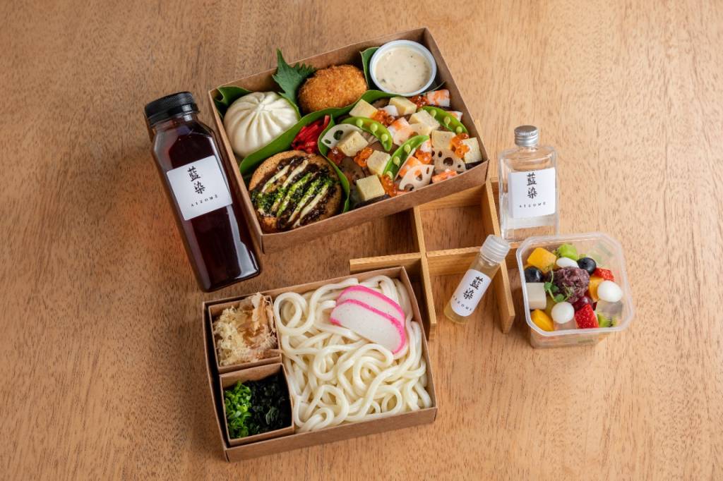 Kit com garrafas de bebidas, caixas com comidinhas como macarrão udon e croquete