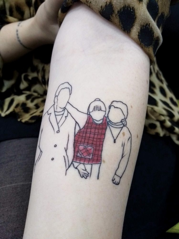 foto do braço de thais que mostra a tatuagem que reproduz a cena dela sendo abraçada pelos avós