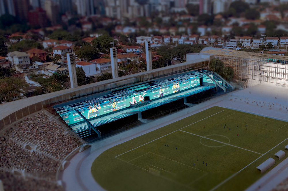 A imagem mostra um projeção da futura área em baixo da arquibancada do Pacaembu destinada para eventos esportivos virtuais. Há um extenso telão e três pequenas arquibancadas no espaço