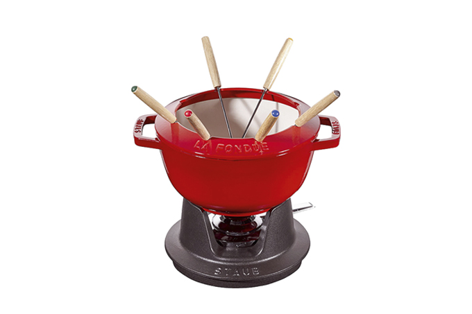 Aparelho de fondue vermelho da Staub em fundo branco.