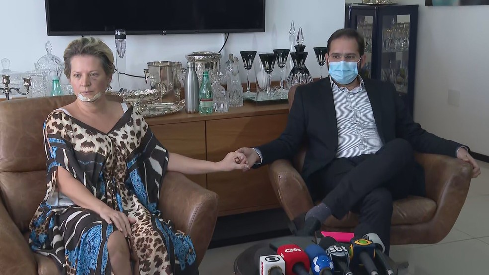 A imagem mostra Joice Hasselmann com o rosto cheio de hematomas e o marido, Daniel França. Os dois seguram as mãos um do outro