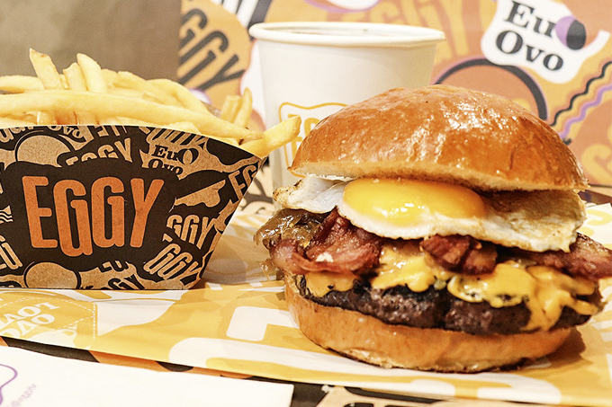 Eggy bacon: com queijo cheddar, ovo frito, picles, bacon e maionese da casa no brioche
