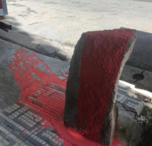 pedra em homenagem a marighella, na calçada de rua dos jardins, coberta de tinta vermelha, que escorreu pela calçada
