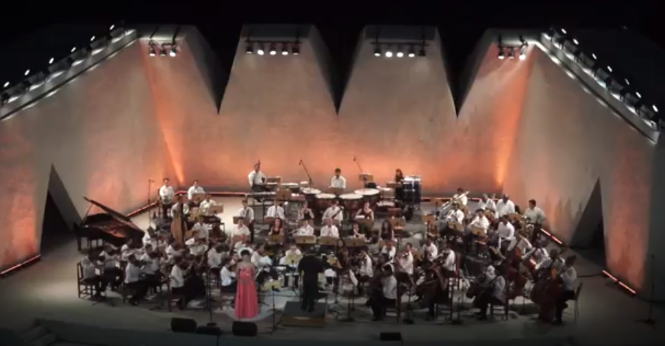 Foto aérea de orquestra posicionada em palco.