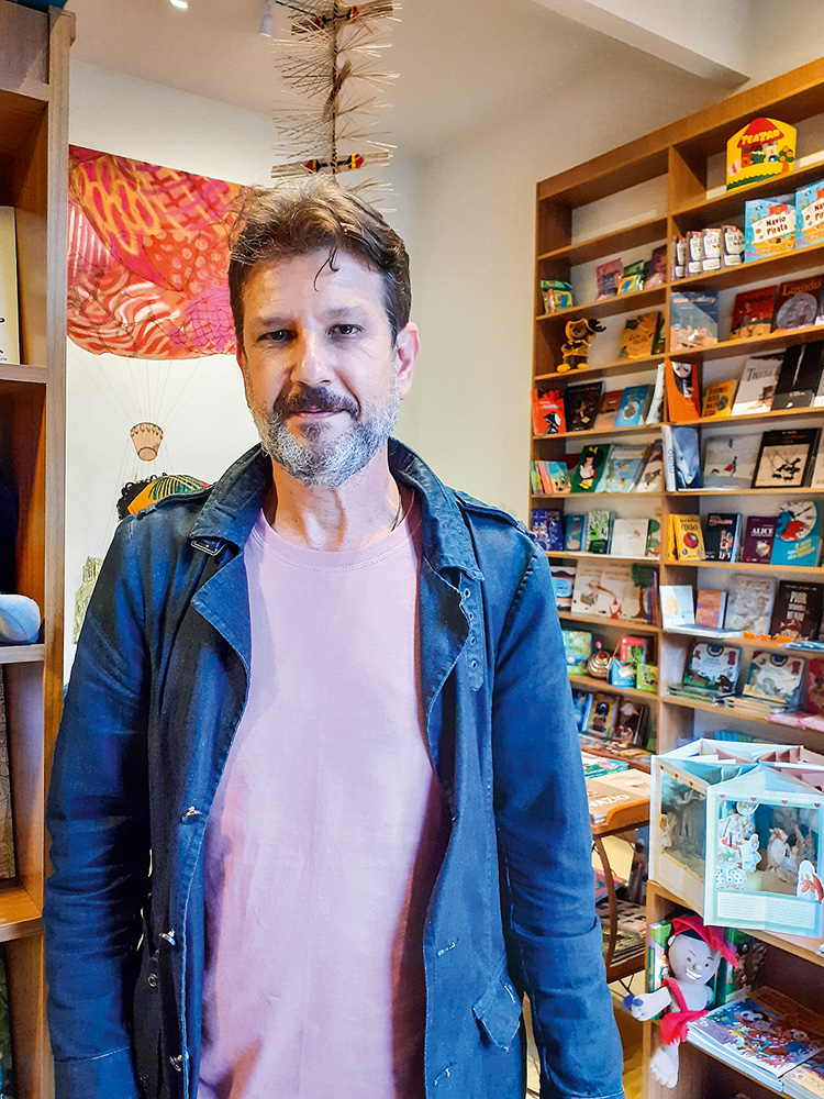 alfredo caseiro de pé em sua livraria posando para a foto