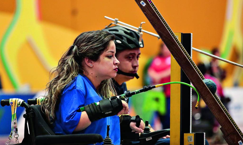 Atleta Evani Calado de perfil competindo na modalidade a bocha adaptada