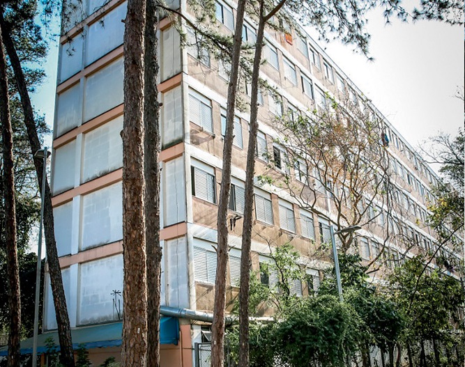 Uma foto de um bloco do CRUSP, na USP. Há árvores em volta