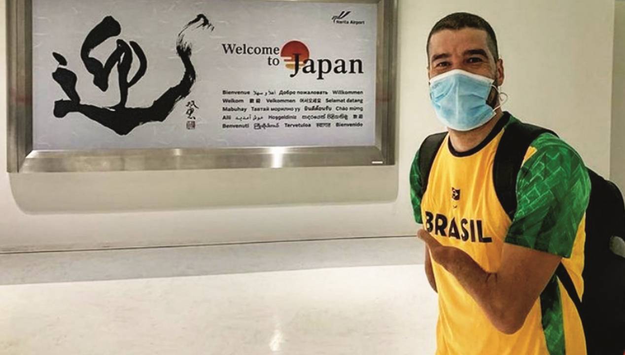 O atleta Daniel Dias posa em frente a uma placa escrito "Bem-vindo ao Japão"