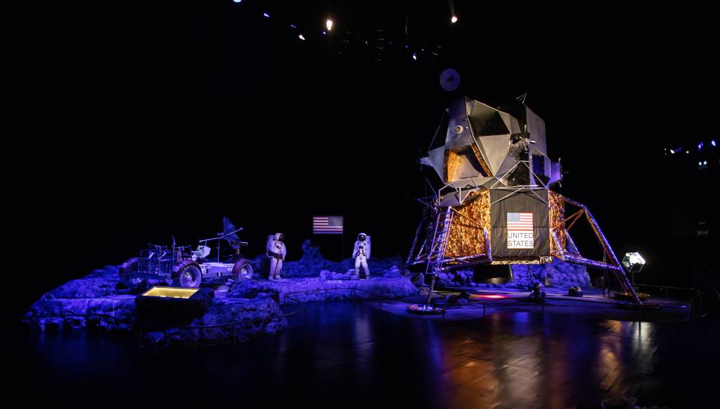 Cenário azulado exibe nave e astronauta.