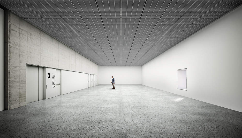 A imagem mostra um sala grande e vazia, com apenas uma pessoa nela, dando noção do tamanho do ambiente.