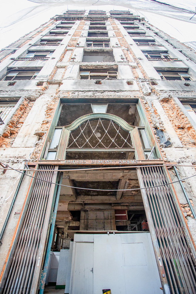 A imagem mostra a fachada, evidentemente desgastada, do Dumont-Adams, em uma visão da calçada olhando para cima.