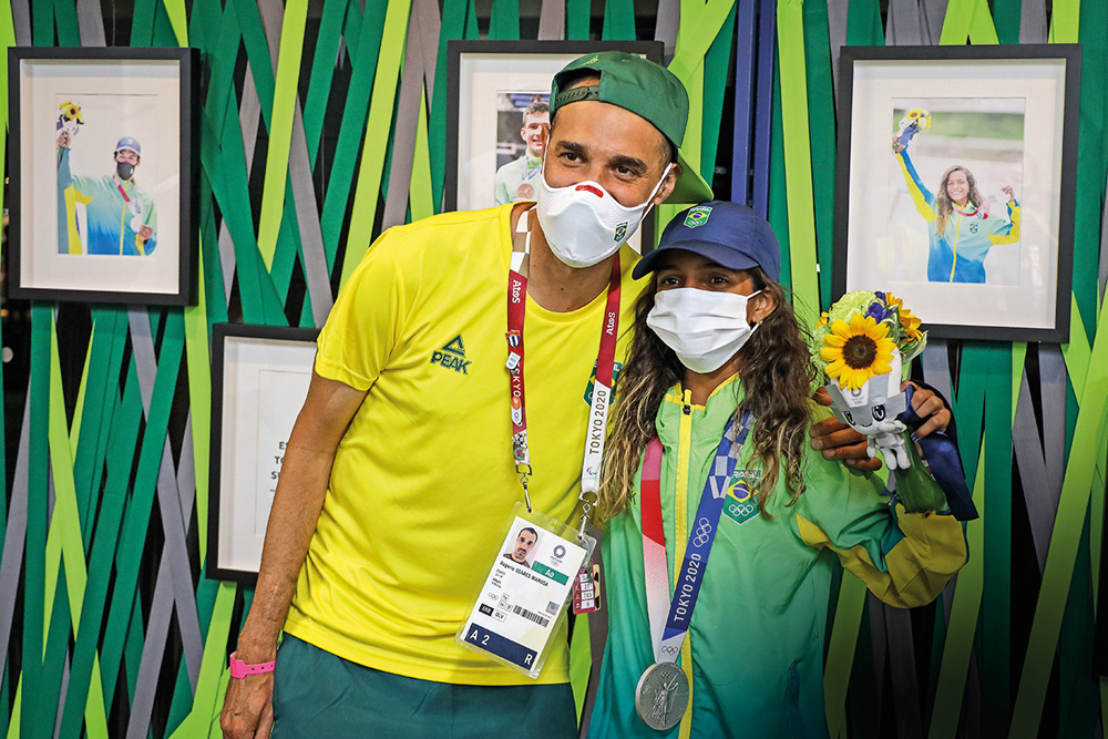 Foto mostra Roger Mancha e Rayssa Leal posando para uma foto, de máscaras, em Tóquio