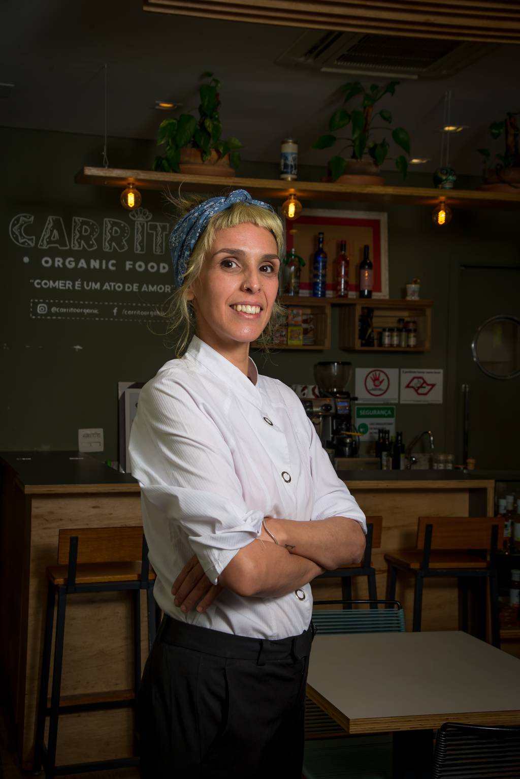 camila borba roger mancha Imagem mostra Camila, com lenço no cabelo e braços cruzados, diante do saguão do restaurante Carrito