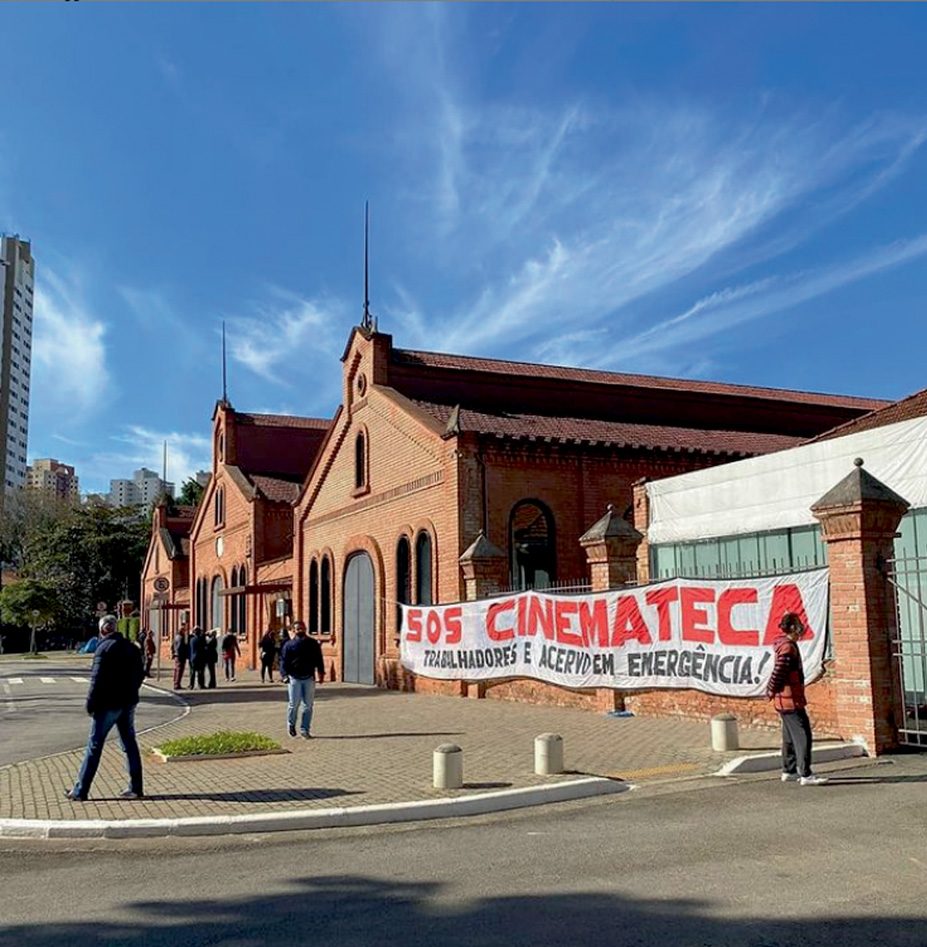 Foto mostra edifícios, a sede da Cinemateca e uma placa escrita 