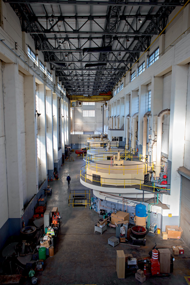 visão de cima de uma sala enorme com as bombas da usina de traição