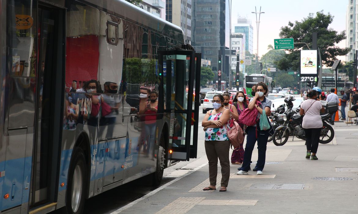 Usuários do transporte público esperam ônibus em ponto da Avenida Paulista