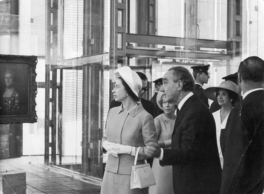 Foto da Rainha Elizabeth e Pietro Maria Bardi (1900-1999). Ela com chapéu, ele de paletó