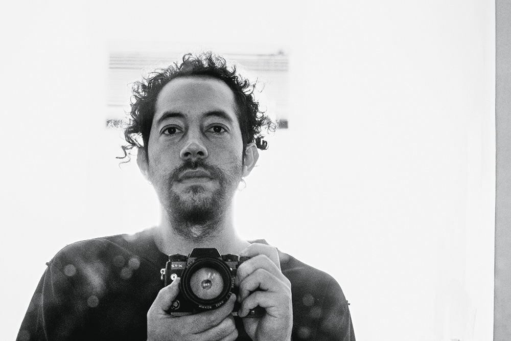 foto em preto e branco de renato custódio capturando a si mesmo com sua câmera fotográfica