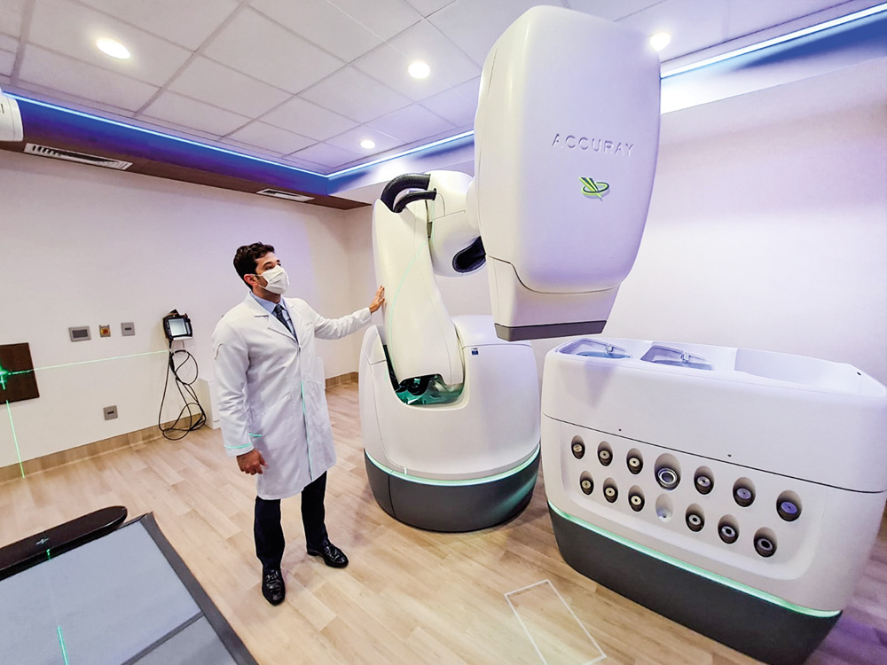 A imagem mostra uma grande máquina branca de uns 3 metros conhecida como Cyberknife.