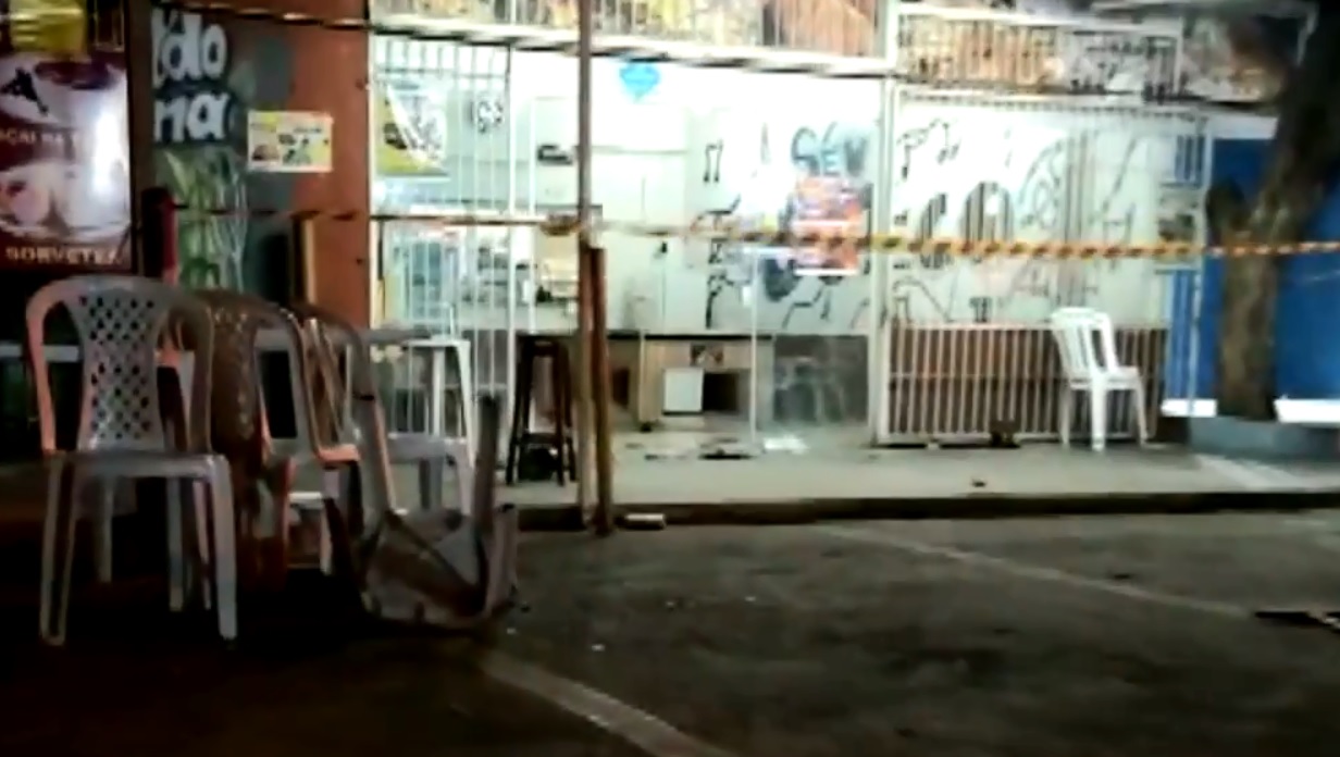 A imagem mostra a entrada do bar, com uma cadeira revirada de ponta de cabeça no chão e um chinelo no asfalto.