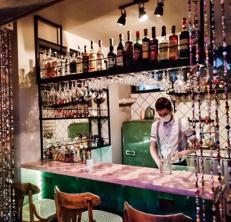 Balcão presente no ambiente do bar Augustín decorado por garrafas de vermute