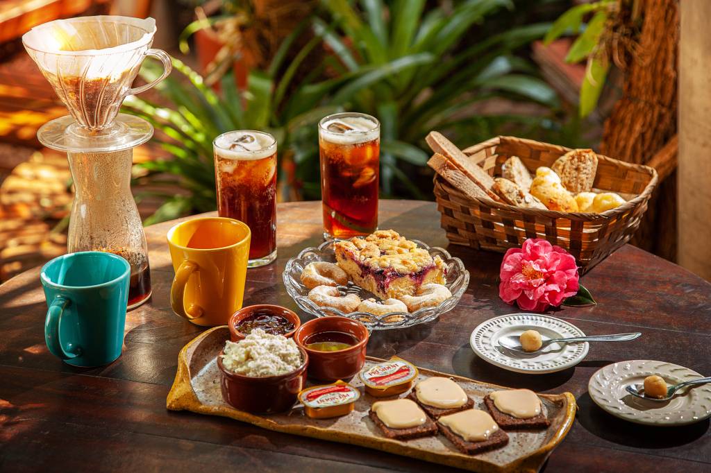 Itens de café da manhã dispostos sobre mesa de madeira.