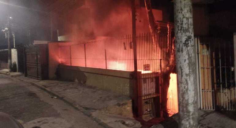 A imagem mostra um terreno sendo incendiado no escuro.