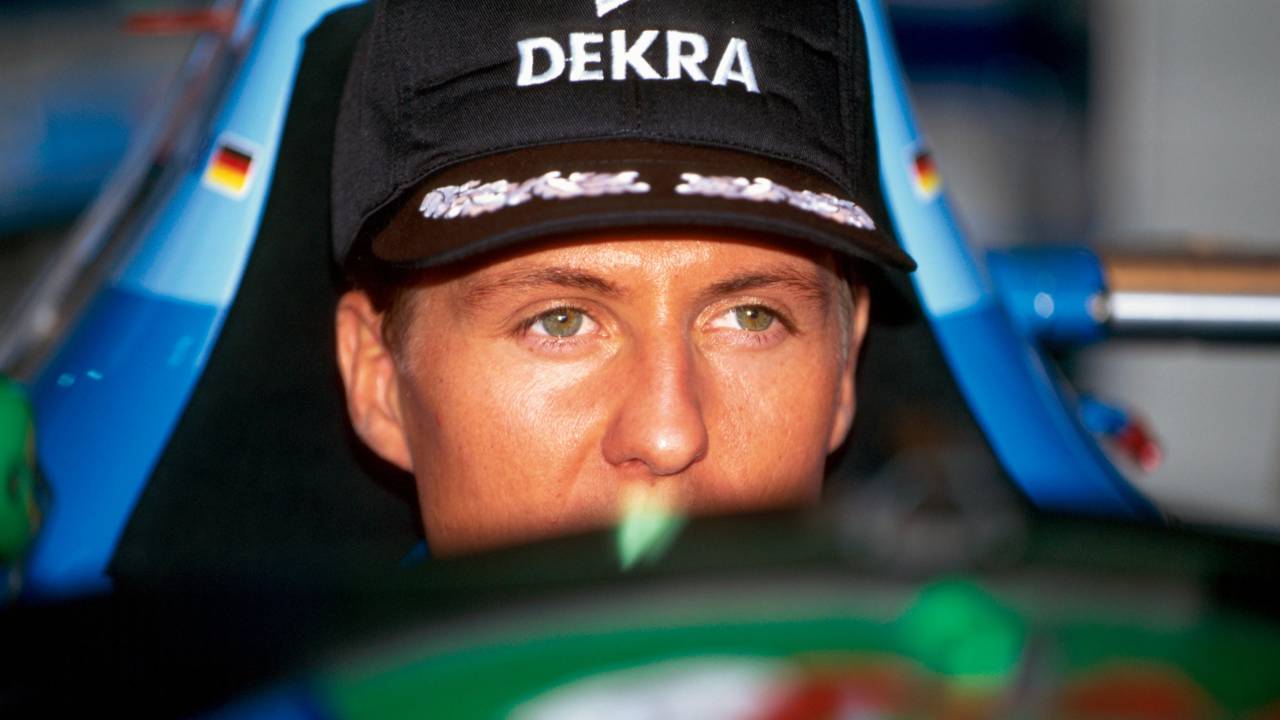 A imagem mostra Schumacher dentro de um carro. Só é possível vê-lo do nariz para cima de dentro do carro de Fórmula 1.
