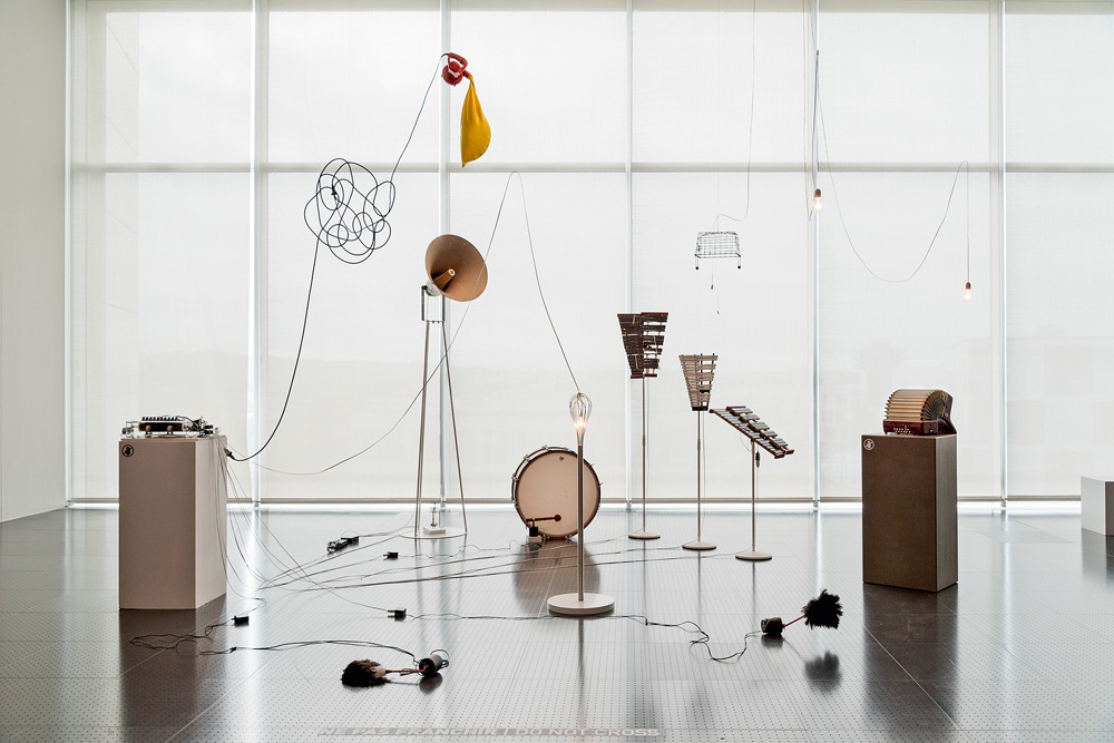 peça de arte de yuko mohri com diversos elementos e instrumentos espalhados em uma sala