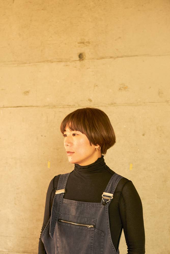 yuko mohri fotografada contra uma parede de perfil
