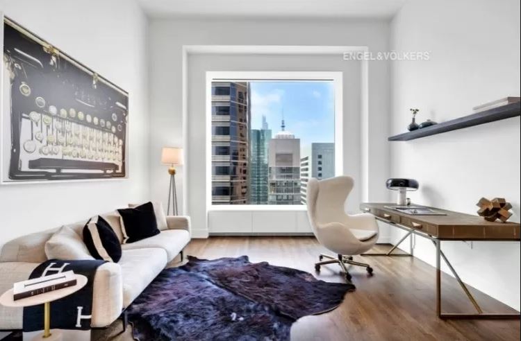escritório-apartamento-de-luxo-432-park-avenue-arranha-céu-milionário-manhattan-problemas-processo-judicial Escritório do apartamento de luxo do 432 Park Avenue, com janela grande, cadeira e escrivaninha de um lado e um sofá do outro