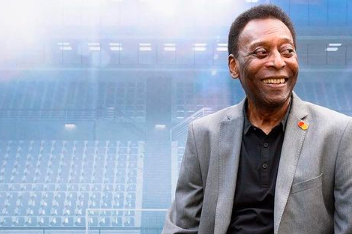 Imagem mostra Pelé sorrindo. Ele usa paletó e aparece na frente de fundo falso, com logo da empresa Mastercard e arquibancadas de estádio de futebol