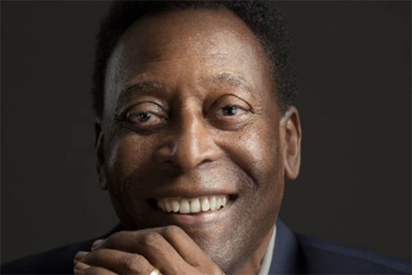 Imagem mostra foto de Pelé sorrindo em estúdio de fotografia