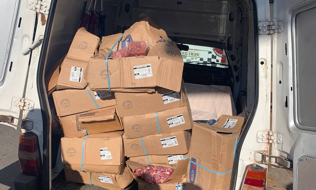 Imagem mostra parte traseira de Fiorino repleta de caixas de papelão com carne