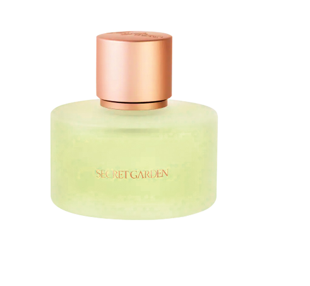 Frasco de perfume transparente com líquido verde e tampa dourada