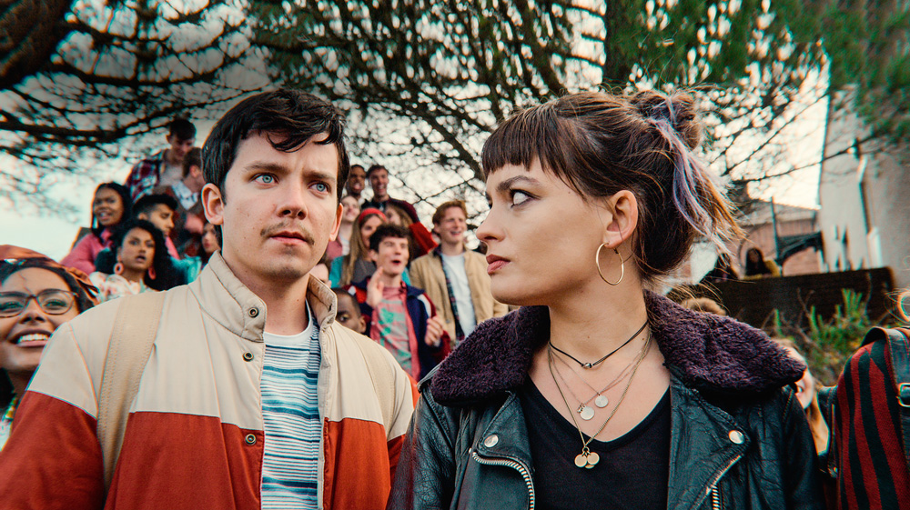 sex education – cred netflix.png A imagem mostra Asa Butterfield olhando para frente e, ao seu lado, Emma Mackey olha para ele.
