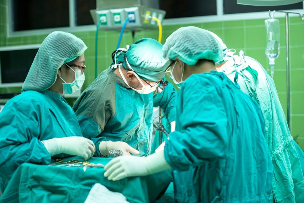 Imagem mostra enfermeiros e médicos em meio a procedimento cirúrgico