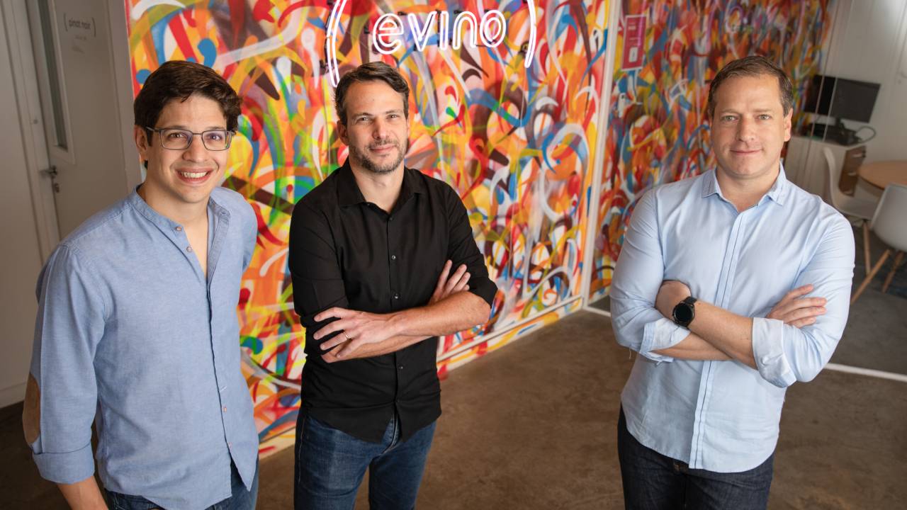 Marcos Leal (óculos), Ari Gorenstein (camisa preta) e Alexandre Bratt, posam no escritório da Evino, em São Paulo, Brasil.