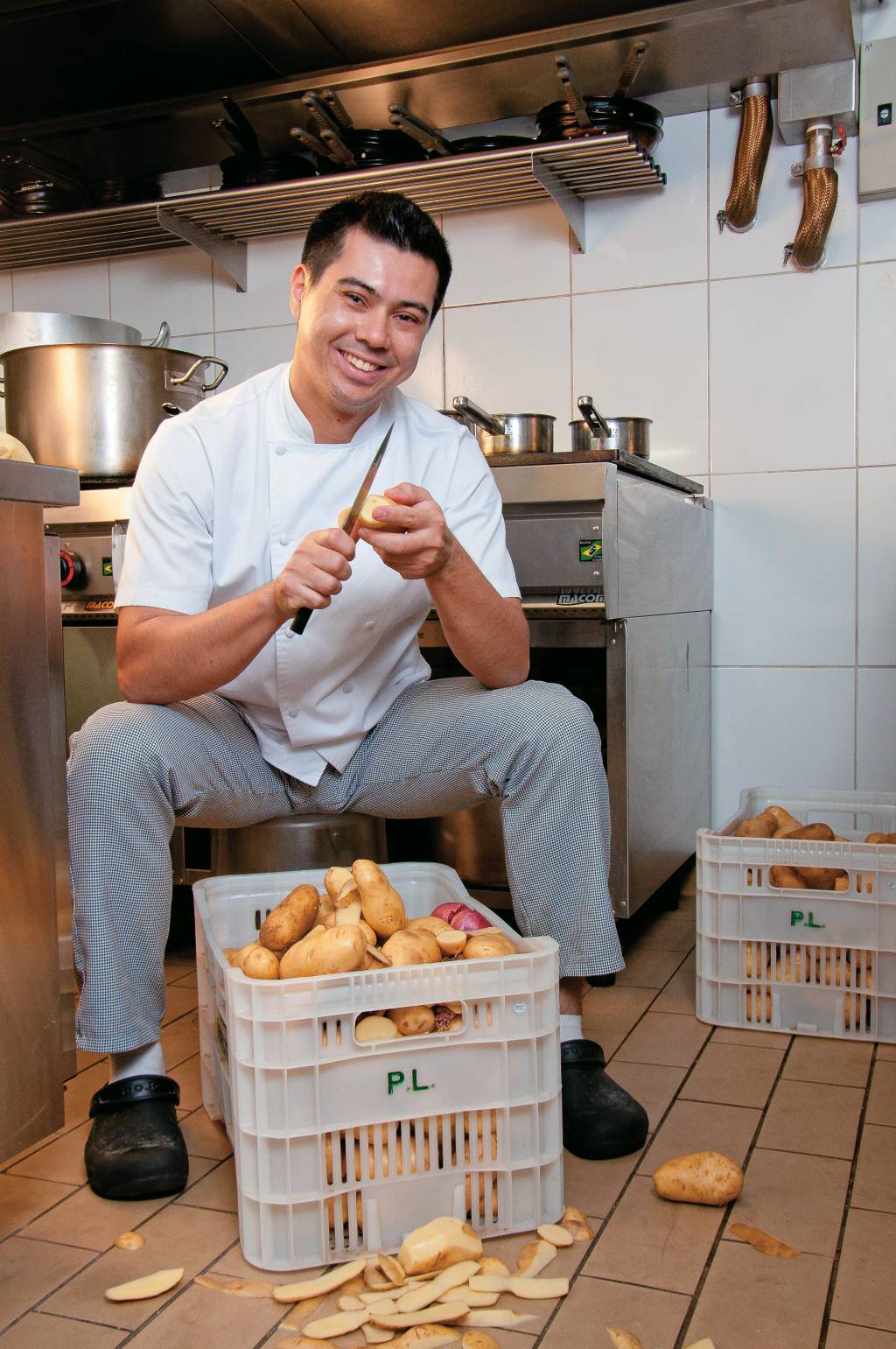 Alberto Landgraf, chef do Epice, posa na cozinha enquanto descasca batatas inglesas