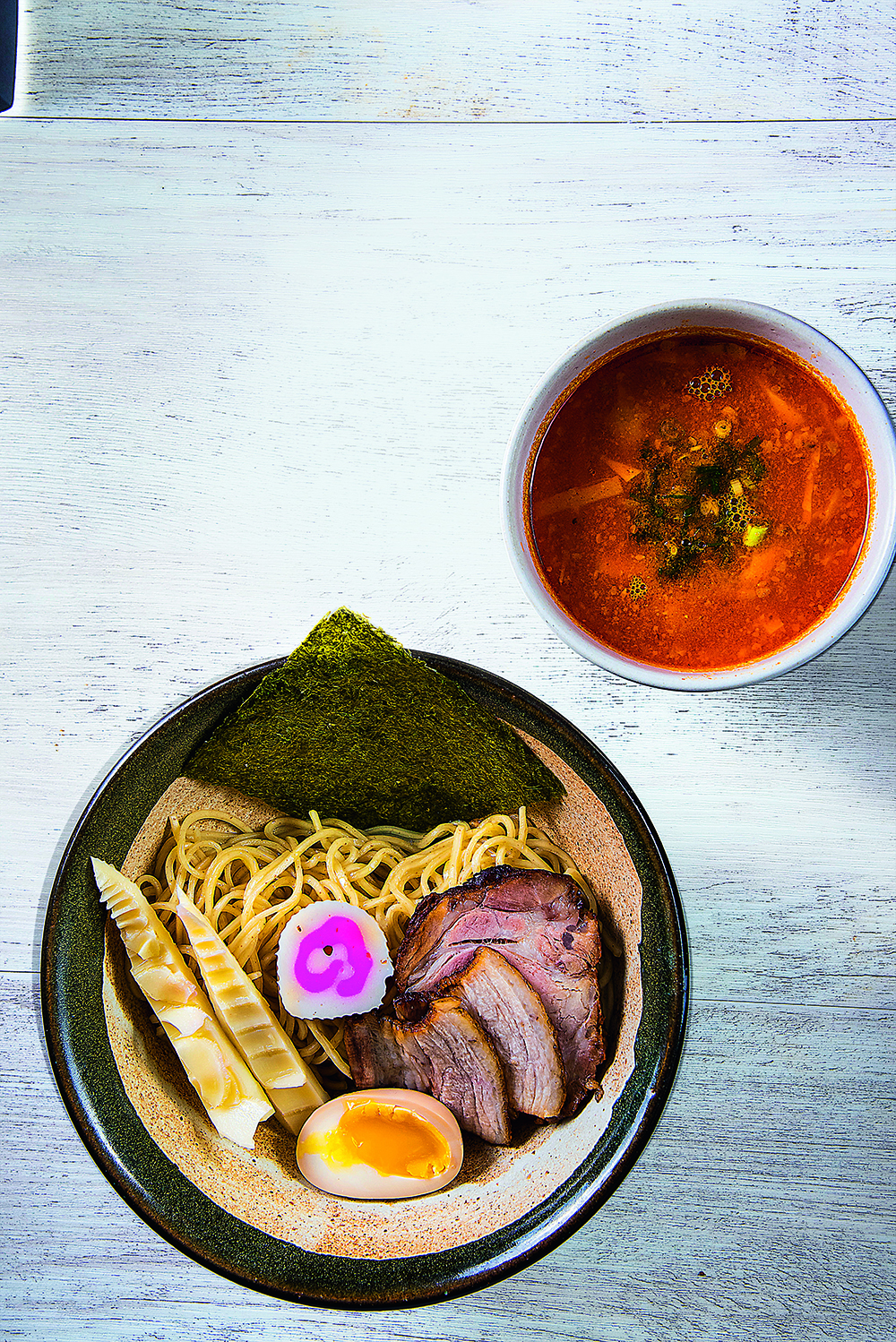 Uma cumbuca de l&aacute;men ao lado de um potinho com molho vermelho.