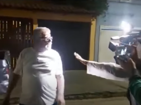 Frame de vídeo em que homem agride repórteres na rua.