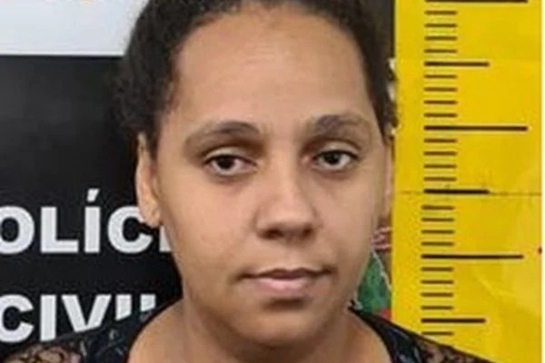 Imagem mostra mulher de cabelos presos na frente de tela em que pode-se ler: "Polícia Civil"