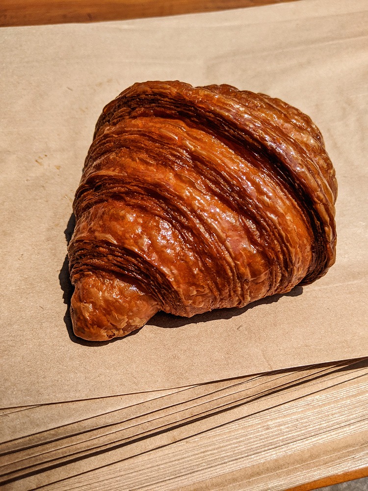 Medialuna, parecida com um croissant, fotografada sobre sacolas de papel