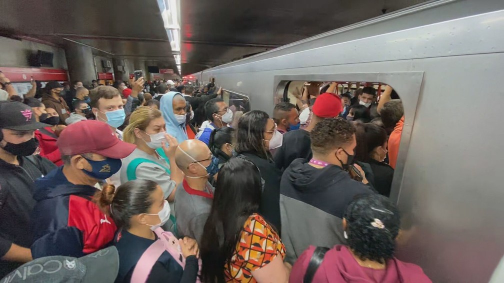 A imagem mostra pessoas aglomeradas tentando embarcar no Metrô de São Paulo