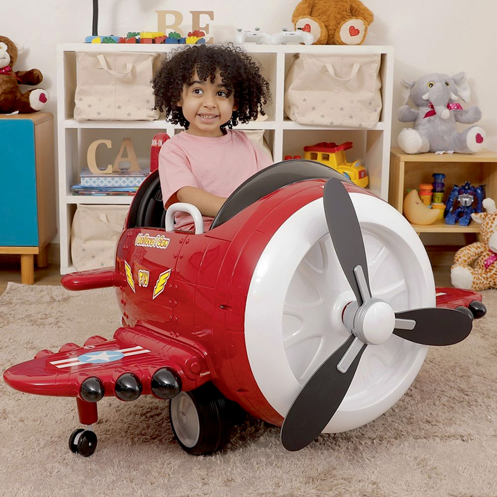 Uma criança sentada em um avião elétrico, como se fosse um carrinho de dirigir