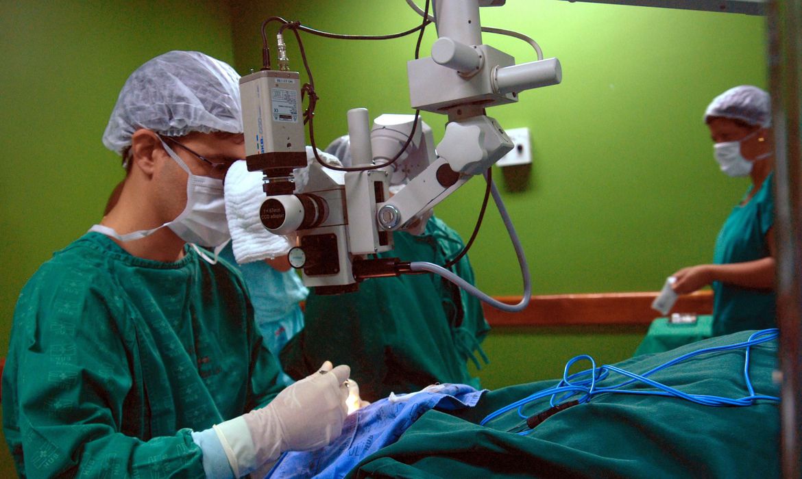 A imagem mostra médicos realizando cirurgia em paciente